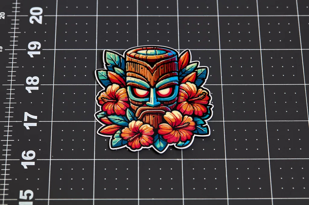 Colorful tiki mask sticker with flowers on a black grid background