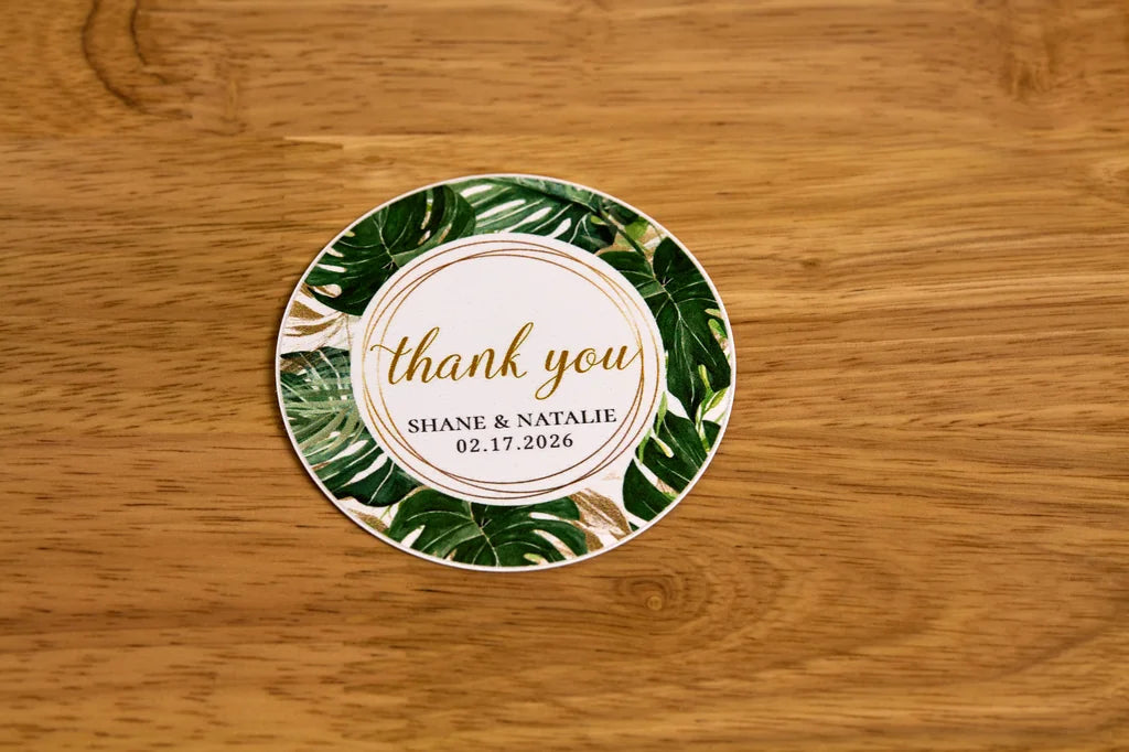 Round paper sticker with 'thank you' message on a wooden surface
