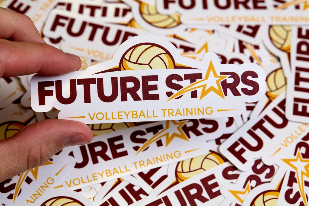 Hand holding a 'Future Stars Volleyball Training' sticker among more stickers.