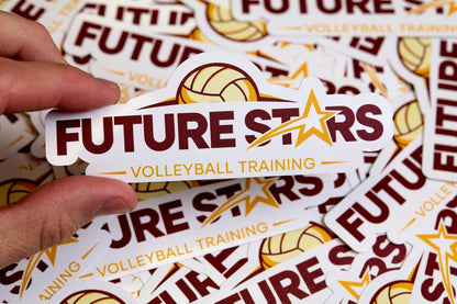 Hand holding a 'Future Stars Volleyball Training' sticker among more stickers.